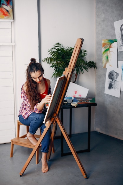 Chica elegante dibuja en un estudio de arte.