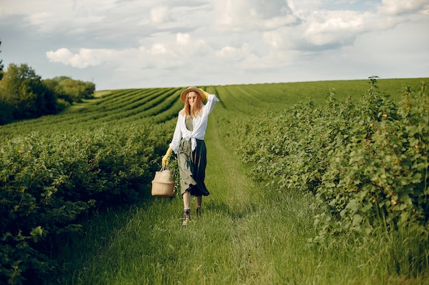 Chica elegante y con estilo en un campo de verano