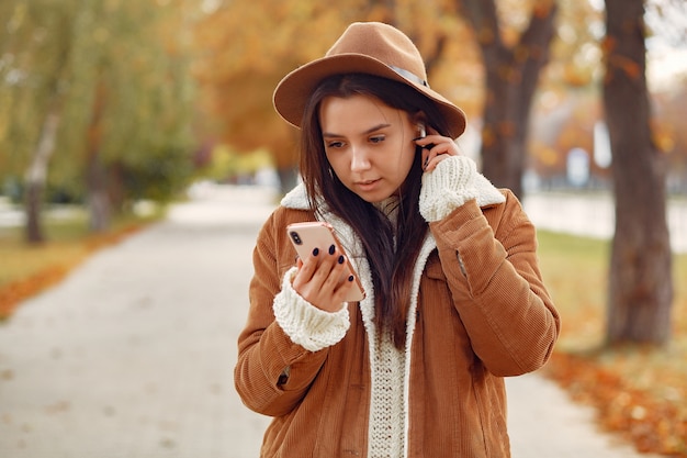 Chica elegante y con estilo en un parque de otoño