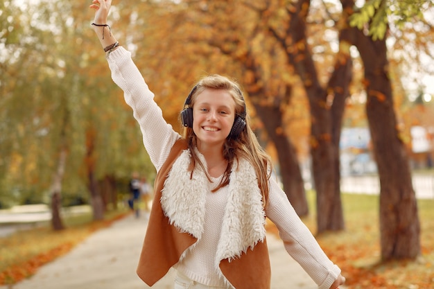 Chica elegante y con estilo en un parque de otoño