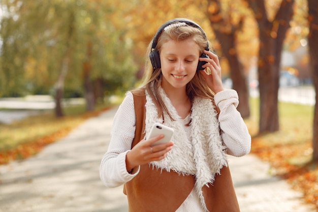 Chica elegante y con estilo en un parque de otoño