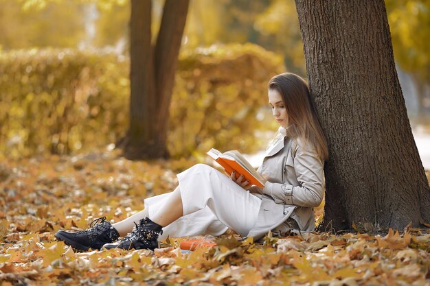 Chica elegante y con estilo en un parque de otoño