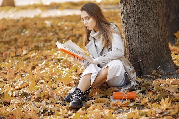 Chica elegante y con estilo en un parque de otoño