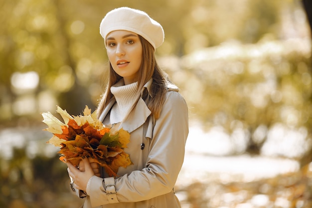 Chica elegante y con estilo en un parque de otoño