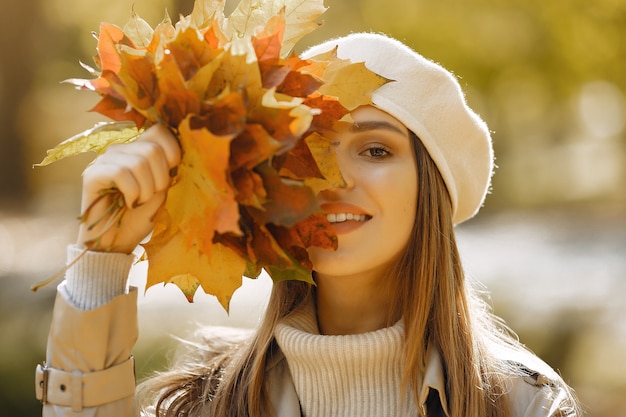 Chica elegante y con estilo en un parque de otoño