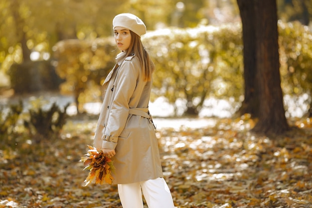 Chica elegante y con estilo en un parque de otoño