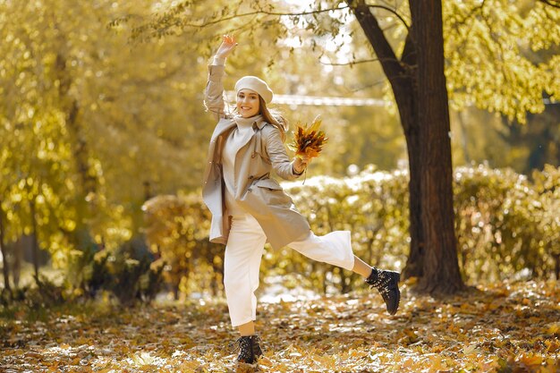 Chica elegante y con estilo en un parque de otoño