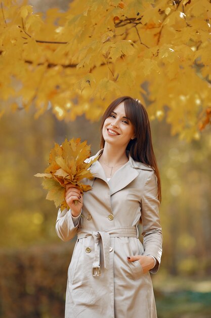 Chica elegante y con estilo en un parque de otoño