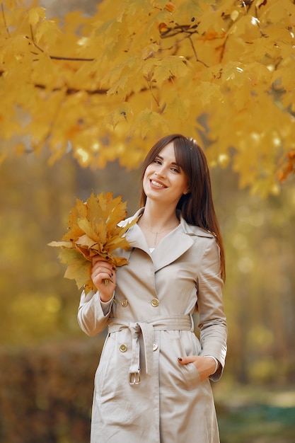 Chica elegante y con estilo en un parque de otoño