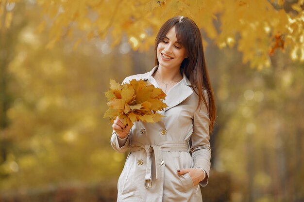 Chica elegante y con estilo en un parque de otoño