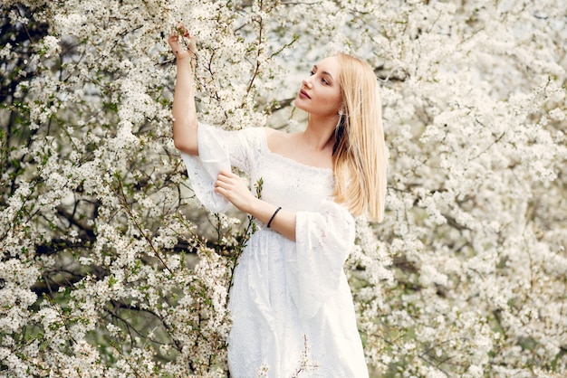 Chica elegante y con estilo en un parque de primavera