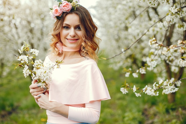 Chica elegante y con estilo en un parque de primavera