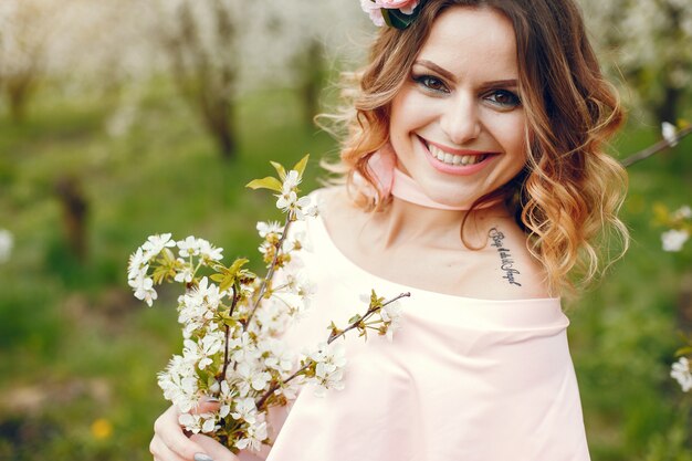 Chica elegante y con estilo en un parque de primavera