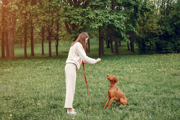 Chica elegante y con estilo en un parque de primavera