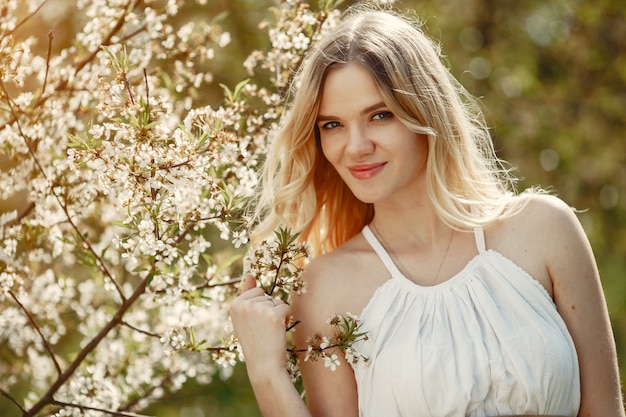 Chica elegante y con estilo en un parque de primavera