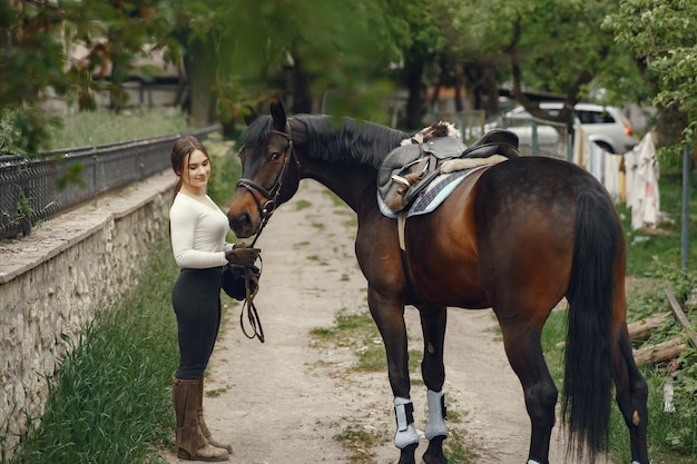 Chica elegante en una granja con un caballo