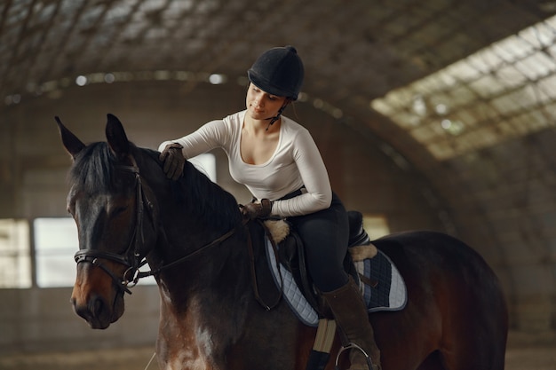 Chica elegante en una granja con un caballo