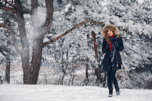 Chica elegante y joven en un parque de invierno