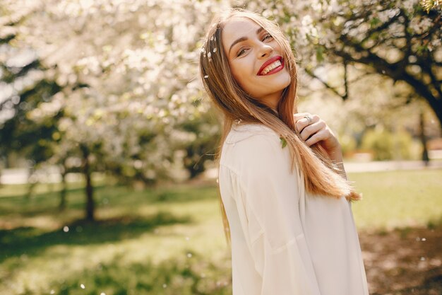 Chica elegante en un parque de primavera