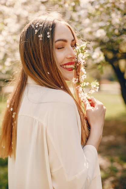 Chica elegante en un parque de primavera