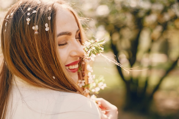 Chica elegante en un parque de primavera