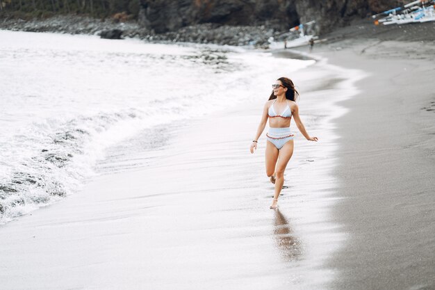 Chica en un elegante traje de baño descansar en la playa