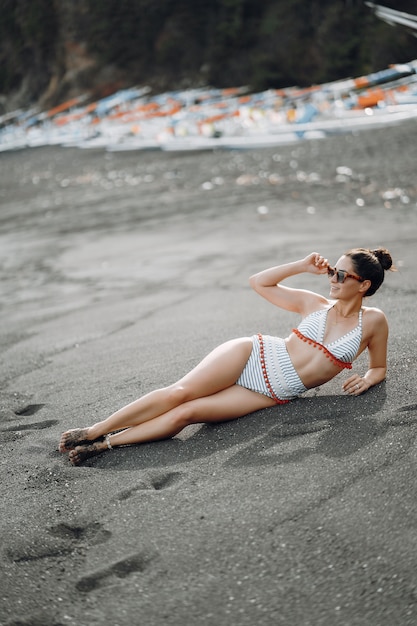 Chica en un elegante traje de baño descansar en la playa