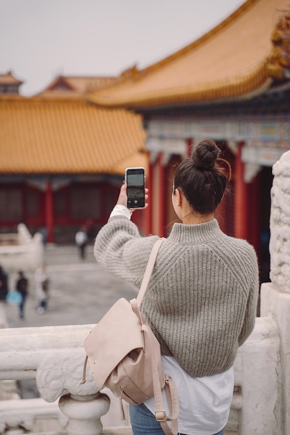 Foto gratuita chica elegante visitando la ciudad prohibida en beijing, china