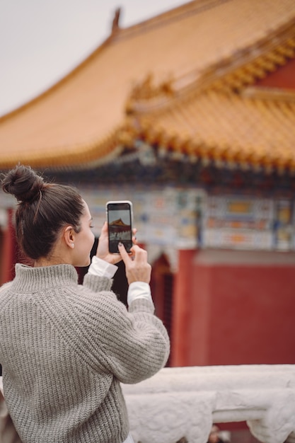 Chica elegante visitando la ciudad prohibida en Beijing, China