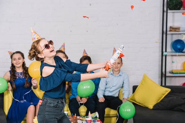 Chica emocionada arruina al confeti popper en la fiesta de cumpleaños