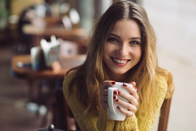 Chica encantadora bebiendo capuchino