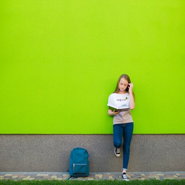 Chica encantadora posando con el libro de texto