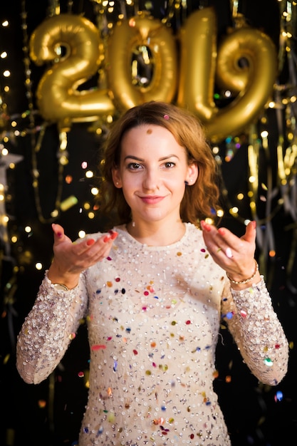 Chica enfrente de decoración de fiesta de año nuevo 2019