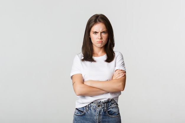 Foto gratuita chica enojada enfurruñada se cruza de brazos y frunce el ceño, sintiéndose ofendida.