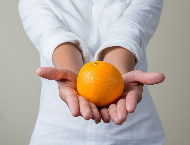 Chica enseñando una naranja