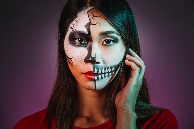 Chica escalofriante con makeup y máscara de halloween