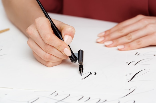 Chica escribiendo caligrafía en postales. Diseño artístico.