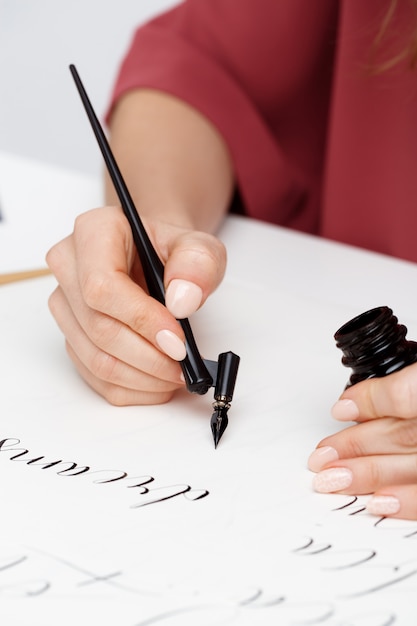 Chica escribiendo caligrafía en postales. Diseño artístico.