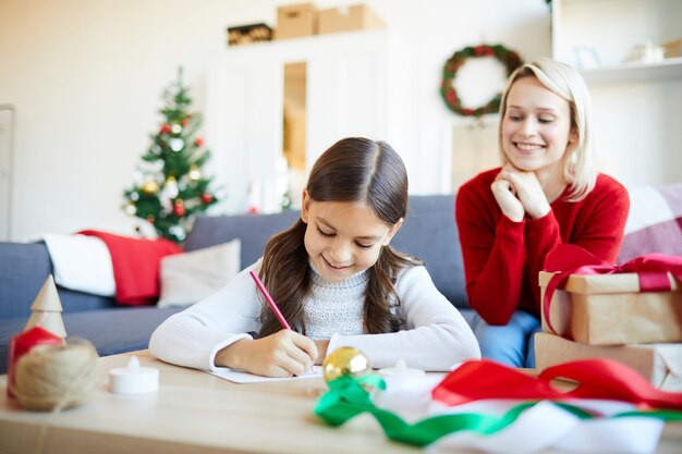 Chica escribiendo una carta para Santa