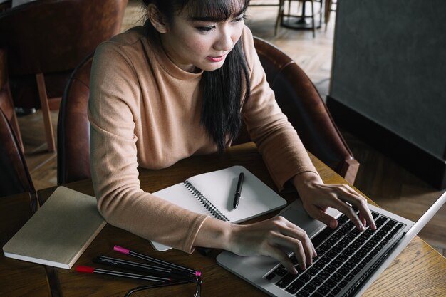 Chica escribiendo en la computadora portátil