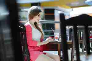 Foto gratuita chica escribiendo en su teléfono mientras se toma un refresco