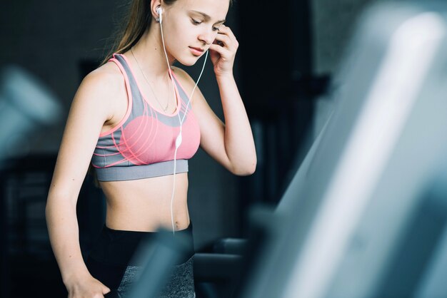 Chica escuchando música en la cinta de correr