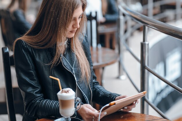 Chica escuchando música mientras mira una tablet