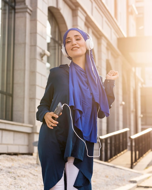 Chica escuchando música a través de auriculares fuera