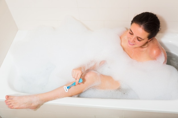 Chica en espuma en la bañera