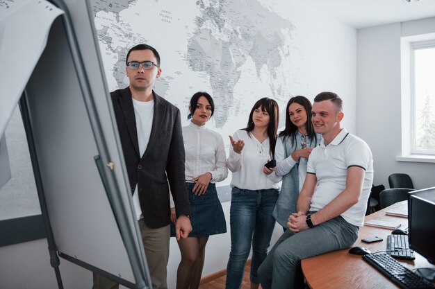 La chica está confundida. Empresarios y gerente trabajando en su nuevo proyecto en el aula