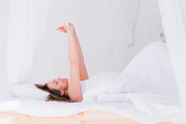 Chica estirándose en la cama