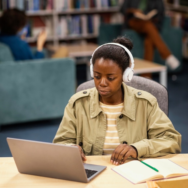 Chica estudiando en la biblioteca de la universidad