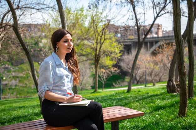 Chica estudiando en un parque