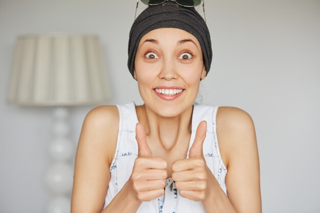 Chica estudiante emocionada mostrando los pulgares para arriba